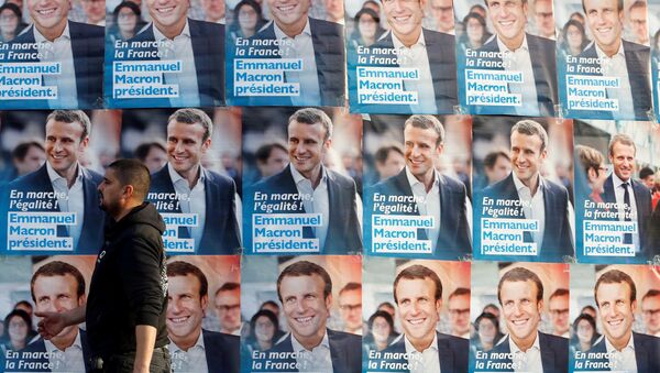 A man walks near posters of Emmanuel Macron, head of the political movement En Marche!, or Onwards!, and candidate for the 2017 presidential elections in France, before Macron's arrival for a meeting in Talence, Southwestern France, March 9, 2017. - Sputnik Afrique