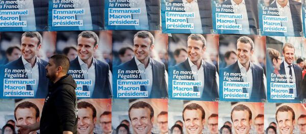 A man walks near posters of Emmanuel Macron, head of the political movement En Marche!, or Onwards!, and candidate for the 2017 presidential elections in France, before Macron's arrival for a meeting in Talence, Southwestern France, March 9, 2017. - Sputnik Afrique