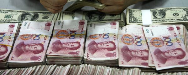 This picture taken on September 24, 2013 shows US dollar notes being counted next to stacks of Chinese 100 yuan (RMB) bank notes at a bank in Huaibei, in eastern China's Anhui province. With deals from London to Singapore, China is seeking to have its yuan currency used more widely around the world and challenge the hegemony of the almighty dollar. - Sputnik Afrique