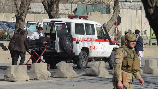 Afghan security personnel carry a victim to an ambulance at the site of a suicide car bomb next to a police base in Kabul on February 1, 2016. - Sputnik Afrique