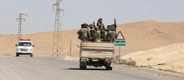 Syrian soldiers flash the v-victory sign in the ancient city of Palmyra on Friday, April 2, 2016. - Sputnik Afrique