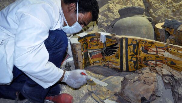 A member of an Egyptian archaeological team works on a wooden coffin discovered in a 3,500-year-old tomb in the Draa Abul Nagaa necropolis, near the southern Egyptian city of Luxor, on April 18, 2017. - Sputnik Afrique