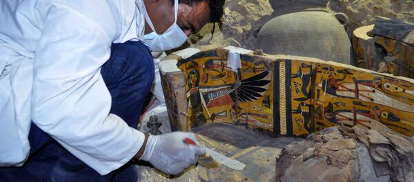 A member of an Egyptian archaeological team works on a wooden coffin discovered in a 3,500-year-old tomb in the Draa Abul Nagaa necropolis, near the southern Egyptian city of Luxor, on April 18, 2017. A member of an Egyptian archaeological team works on a wooden coffin discovered in a 3,500-year-old tomb in the Draa Abul Nagaa necropolis, near the southern Egyptian city of Luxor, on April 18, 2017. - Sputnik Afrique