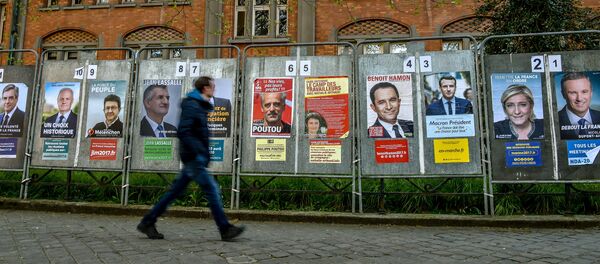 A man walks past campaign posters of the eleven candidates running for the French presidential election in Lille on April 10, 2017. - Sputnik Afrique