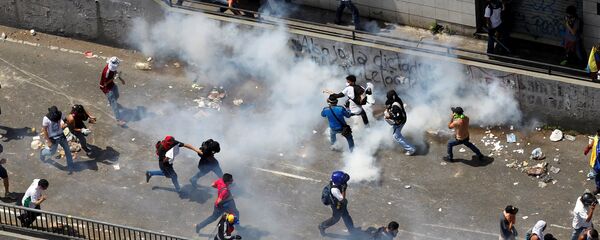 Demonstrators react during clashes with the riot police during a rally in Caracas, Venezuela, April 8, 2017 - Sputnik Afrique