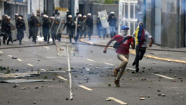 Demonstrators run away during a rally against Venezuela's President Nicolas Maduro's government in Caracas, Venezuela April 10, 2017 - Sputnik Afrique
