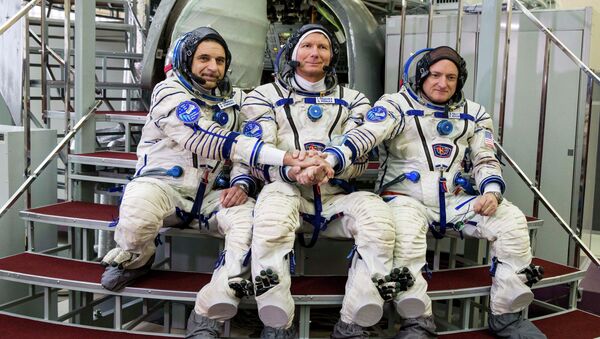 US astronaut Scott Kelly, right, Russian cosmonauts Gennady Padalka, center, and Mikhail Korniyenko pose before their final preflight practical examination in a mock-up of a Soyuz TMA space craft at Russian Space Training Center in Star City, outside Moscow, Russia - Sputnik Afrique