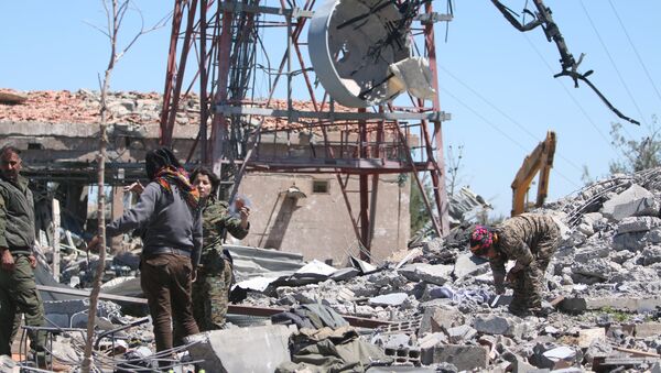 Fighters from the Kurdish People's Protection Units (YPG) inspect the damage at their headquarters after it was hit by Turkish airstrikes in Mount Karachok near Malikiya, Syria April 25, 2017. - Sputnik Afrique