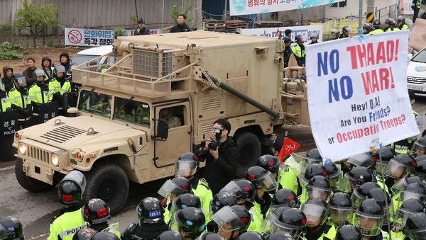 Protesters and police stand by as trailers carrying US THAAD missile defence equipment enter a deployment site in Seongju, early on April 26, 2017. - Sputnik Afrique