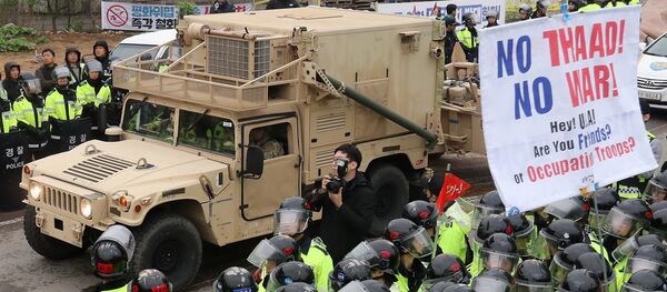 Protesters and police stand by as trailers carrying US THAAD missile defence equipment enter a deployment site in Seongju, early on April 26, 2017. - Sputnik Afrique