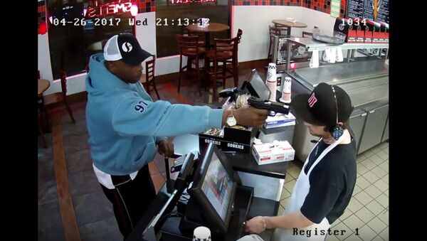 Un homme armé menace le caissier d'un café, il riposte par un poker face (Vidéo) - Sputnik Afrique