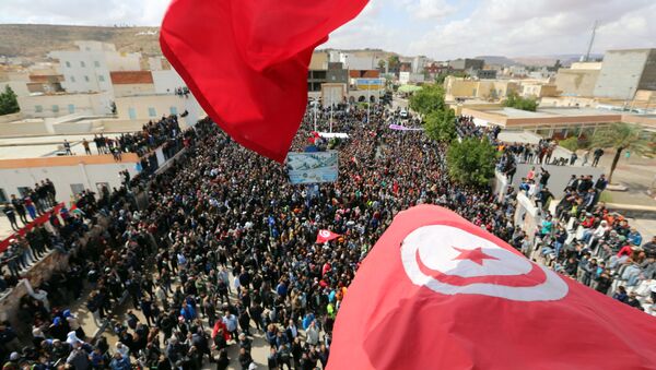 Tunisians wave their national flag as they take part in a general strike against marginalization and to demand development and employment on April 11, 2017, in Tataouine, south of Tunisia. - Sputnik Afrique