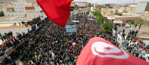 Tunisians wave their national flag as they take part in a general strike against marginalization and to demand development and employment on April 11, 2017, in Tataouine, south of Tunisia. - Sputnik Afrique