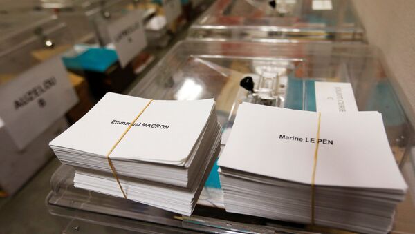 Ballots with the names of 2017 French presidential election candidates Emmanuel Macron (L) and Marine Le Pen are seen near ballot boxes on the eve of the second round of the French presidential election, at a polling station in Tulle, France, May 6, 2017 - Sputnik Afrique
