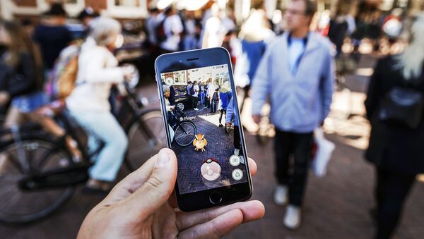 Gamers play with the Pokemon Go application on their mobile phone, at the Grote Markt in Haarlem, on July 13, 2016 - Sputnik Afrique