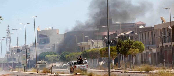 Fighters ride a pickup truck as smoke rises during a battle with Islamic State fighters in neighborhood Number Two in Sirte, Libya - Sputnik Afrique