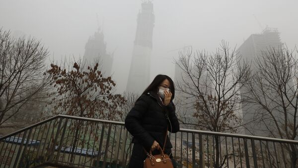 A woman wearing a mask for protection against air pollution walks on a pedestrian overhead bridge in Beijing as the capital of China is shrouded by heavy smog on Tuesday, Dec. 20, 2016 - Sputnik Afrique