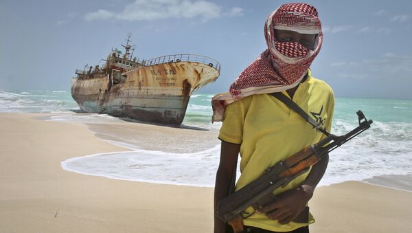In this Sunday, Sept. 23, 2012 file photo, masked Somali pirate Hassan stands near a Taiwanese fishing vessel that washed up on shore after the pirates were paid a ransom and released the crew, in the once-bustling pirate den of Hobyo, Somalia. - Sputnik Afrique