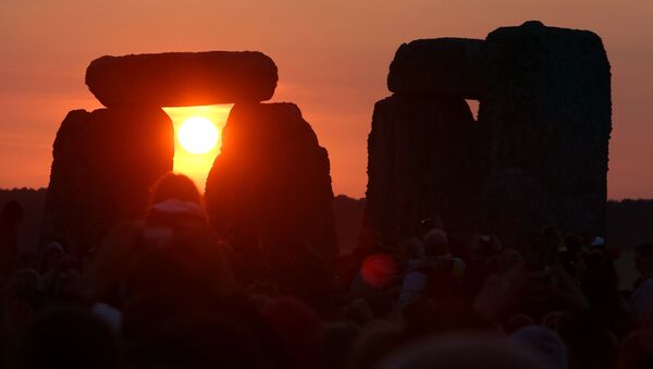 The rising sun is seen through the standing stones at the prehistoric monument Stonehenge, near Amesbury in Southern England, on June 21, 2014, as revelers gather to celebrate the 2014 summer solstice, marking the longest day of the year. - Sputnik Afrique