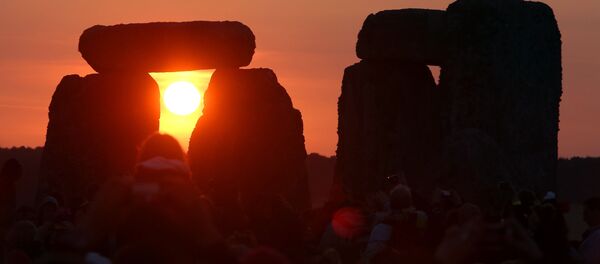 The rising sun is seen through the standing stones at the prehistoric monument Stonehenge, near Amesbury in Southern England, on June 21, 2014, as revelers gather to celebrate the 2014 summer solstice, marking the longest day of the year. - Sputnik Afrique