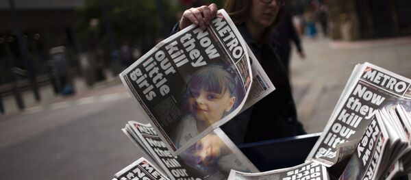 A woman picks a newspaper reporting the news on the suicide attack at a concert by Ariana Grande that killed more than 20 people as it ended Monday night in central Manchester, Britain, Wednesday, May 24, 2017. - Sputnik Afrique