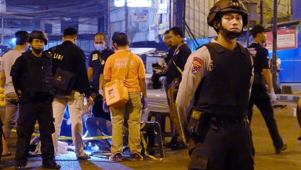 Indonesian police officers stand guard outside Kampung Melayu bus terminal in Jakarta as investigators check a body part found after a suicide bomb blast on May 24, 2017. - Sputnik Afrique