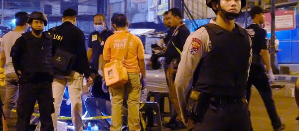 Indonesian police officers stand guard outside Kampung Melayu bus terminal in Jakarta as investigators check a body part found after a suicide bomb blast on May 24, 2017. - Sputnik Afrique