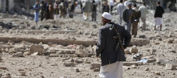 A Houthi militant walks at the site of Saudi-led air strikes in Yemen's capital Sanaa October 28, 2015 - Sputnik Afrique