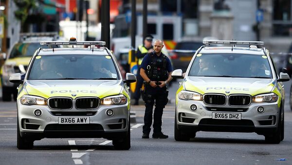 An armed police officer stand next to police vehicles outside Borough Market after an attack left 6 people dead and dozens injured in London, Britain, June 4, 2017. - Sputnik Afrique