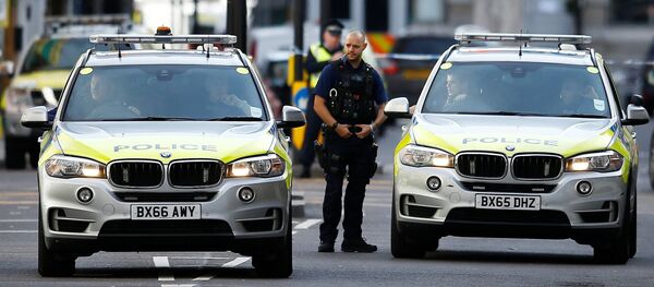 An armed police officer stand next to police vehicles outside Borough Market after an attack left 6 people dead and dozens injured in London, Britain, June 4, 2017. - Sputnik Afrique