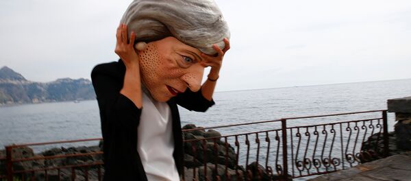 A protester wears a mask depicting Britain's Prime Minister Theresa May during a demonstration organised by Oxfam in Giardini Naxos, Sicily, Italy, May 25, 2017. - Sputnik Afrique
