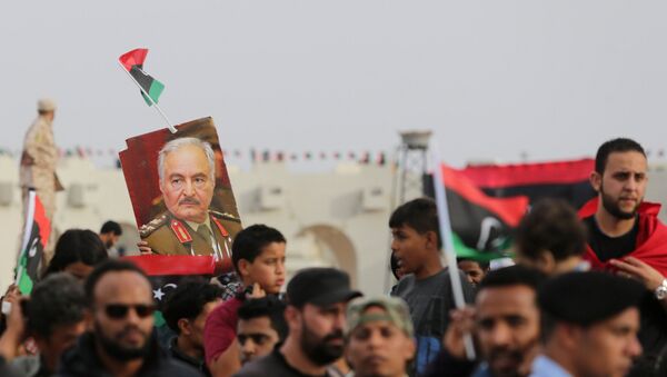 A poster of Libyan military commander Khalifa Haftar is held during celebrations marking the third anniversary of Libyan National Army's ÒDignityÓ operation against Islamists and other opponents, in Benghazi, Libya May 16, 2017. - Sputnik Afrique
