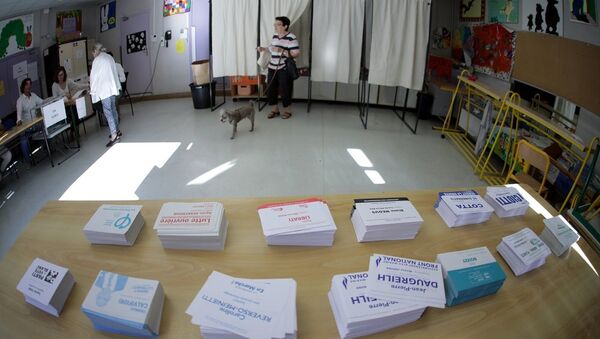 A person leaves a polling booth during the first round of French parliamentary election in Nice - Sputnik Afrique