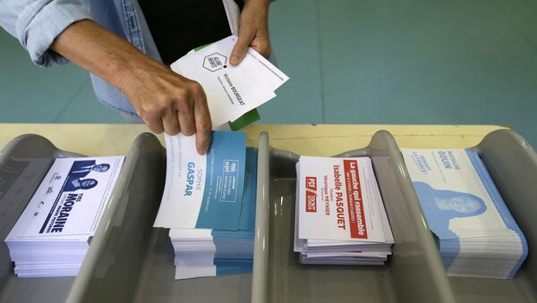 Voter picks up ballots at a polling station before voting for the first round of parliamentary elections in Marseille, southern France, Sunday, June 11, 2017 - Sputnik Afrique