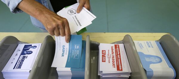 Voter picks up ballots at a polling station before voting for the first round of parliamentary elections in Marseille, southern France, Sunday, June 11, 2017 - Sputnik Afrique