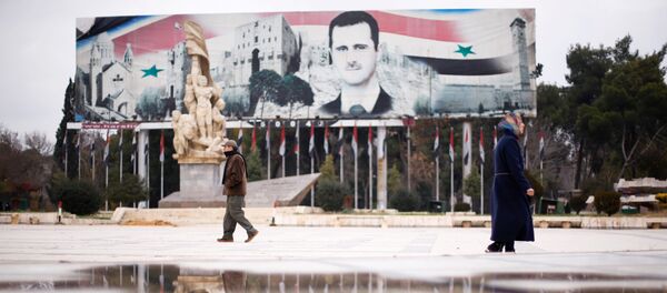 People walk past a billboard depicting Syria's President Bashar al-Assad at Saadallah al-Jabri Square, in the government controlled area of Aleppo, Syria December 17, 2016 - Sputnik Afrique
