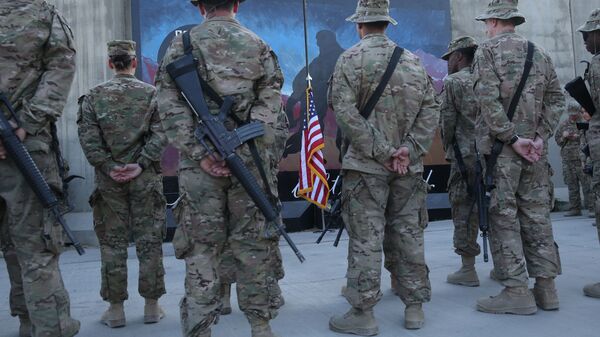 Des militaires américains se tiennent devant un drapeau américain lors d'une cérémonie à l'occasion du treizième anniversaire des attentats terroristes du 11 septembre à Bagram Airfield, en Afghanistan, le jeudi 11 septembre 2014 - Sputnik Afrique