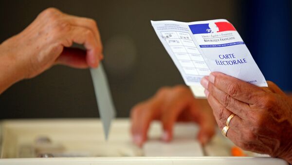 Volunteer holds election card as person casts ballot in Marseille - Sputnik Afrique