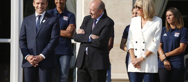 French President Emmanuel Macron (C), his wife Brigitte Macron (C) and French Interior Minister Gerard Collomb attend a ceremony to celebrate the victory of Lyon's football team during the UEFA Women's Champions League - Sputnik Afrique