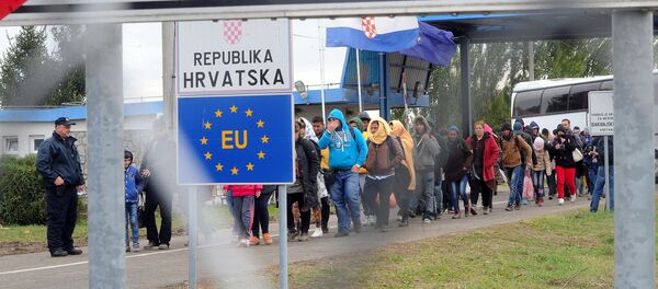 Migrants cross the border at the Hungarian Beremend station on September 30, 2015 as local workers prepare a new transit zone here. - Sputnik Afrique