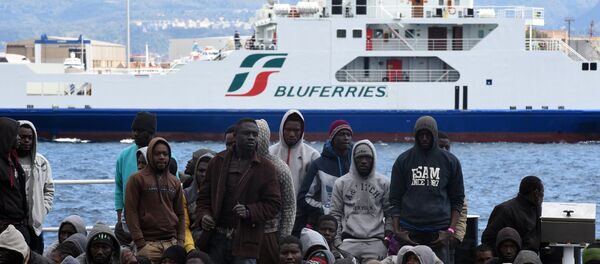 Migrants and refugees wait to disembark in the port of Messina following a rescue operation at sea by the Italian Coast Guard ship Diciotti on March 17, 2016 in Sicily. - Sputnik Afrique