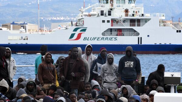 Migrants and refugees wait to disembark in the port of Messina following a rescue operation at sea by the Italian Coast Guard ship Diciotti on March 17, 2016 in Sicily. - Sputnik Afrique