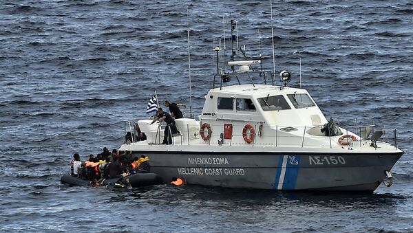 Hellenic coast guard personnel rescue refugees and migrants on a dinghy as they try to reach the Greek island of Lesbos while crossing the Aegean sea from Turkey on September 29, 2015 - Sputnik Afrique