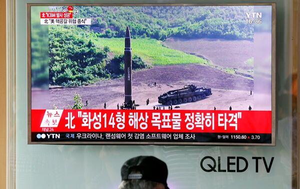 Les gens regardent une émission consacrée au tir nord-coréen du 4 juillet - Sputnik Afrique