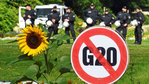 A G20 protest sign is seen in front of a row of police men during a demonstration against the ban of Hamburg's authorities of a G20 protestors camp in the Stadtpark park in Hamburg, Germany June 26, 2017. - Sputnik Afrique