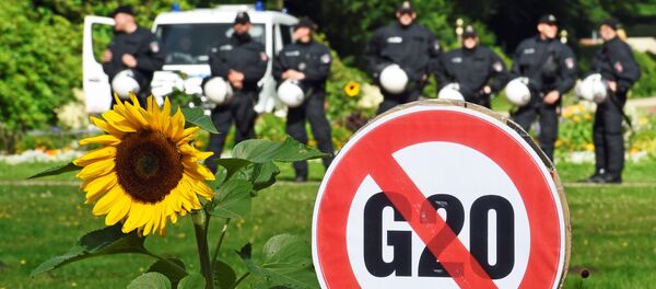 A G20 protest sign is seen in front of a row of police men during a demonstration against the ban of Hamburg's authorities of a G20 protestors camp in the Stadtpark park in Hamburg, Germany June 26, 2017. - Sputnik Afrique
