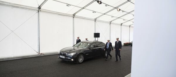 Security personnel walk along a vehicle transporting Chinese President Xi Jinping as he leaves following his visit to a section of the Hong Kong-Zhuhai-Macau Bridge which is under construction in Hong Kong Saturday, July 1, 2017 - Sputnik Afrique