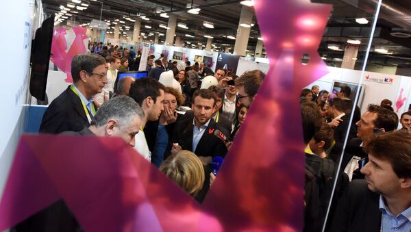French Economy Minister Emmanuel Macron (C) and CEO of Business France, a national agency promoting foreign investment in France, Muriel Penicaud (4thL) visit French technology startups, at the CES 2016 consumer electronics show in Las Vegas, Nevada, January 7, 2016. - Sputnik Afrique