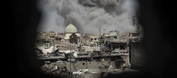 A bomb explodes behind the al-Nuri mosque complex, as seen through a hole in the wall of a house, as Iraqi Special Forces move toward Islamic State militant positions in the Old City of Mosul, Iraq, Thursday, June 29, 2017. - Sputnik Afrique