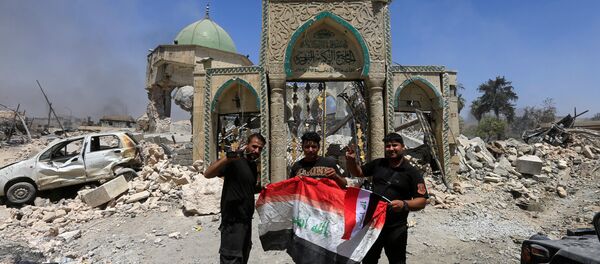 Les membres du Service antiterroriste posent pour une photo avec un drapeau irakien devant les ruines de la mosquée Grand al-Nuri dans la vieille ville de Mossoul, en Irak, le 30 juin 2017 - Sputnik Afrique